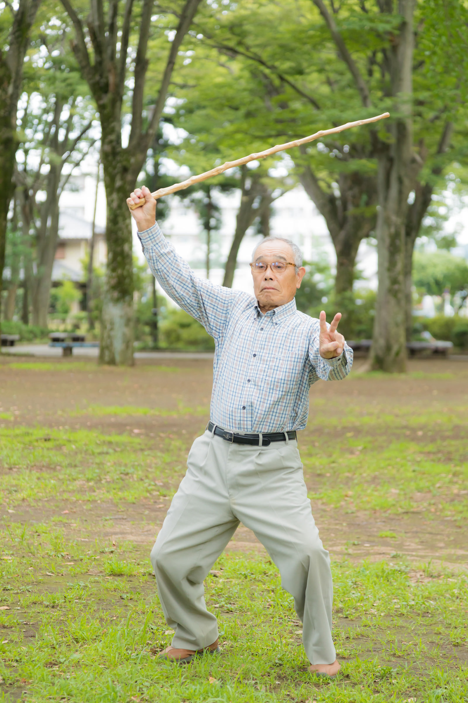 公園で元気にポーズを決めるおじいさん